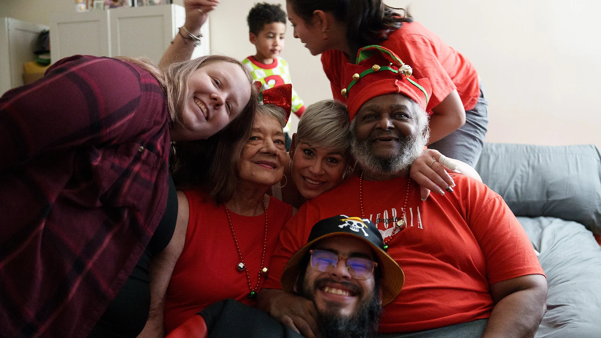 The whole family piled onto the sofa in red