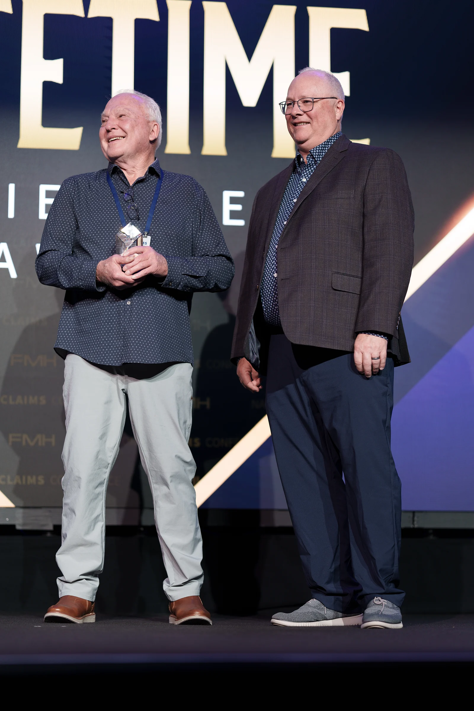 Two men on stage with the lifetime award