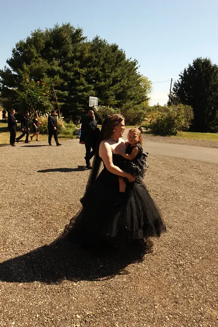 The bride carrying her daughter up the drive