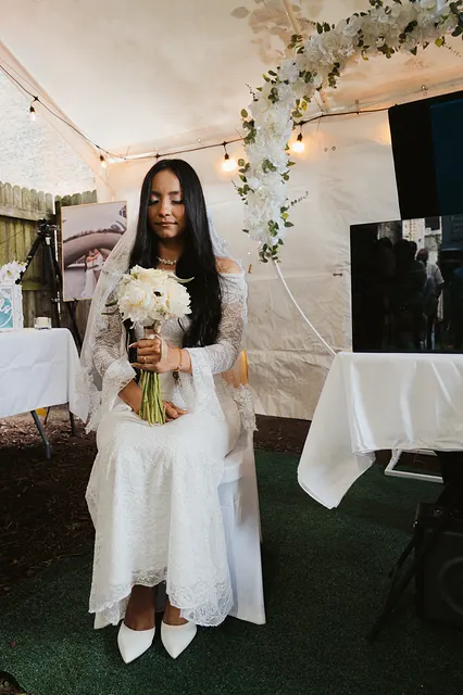 The bride with her bouquet under the tent