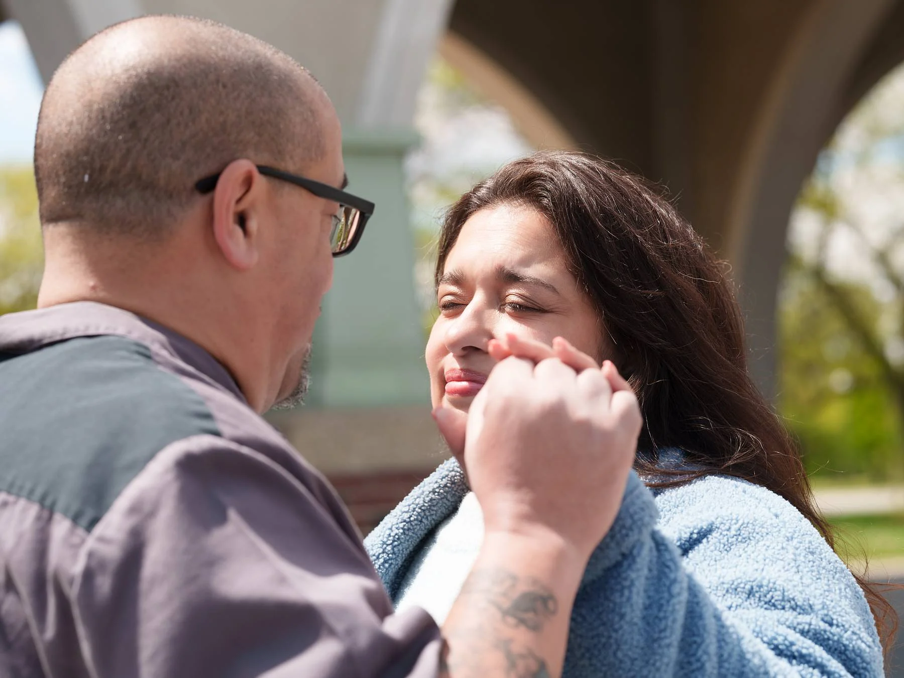 He brushes her cheek