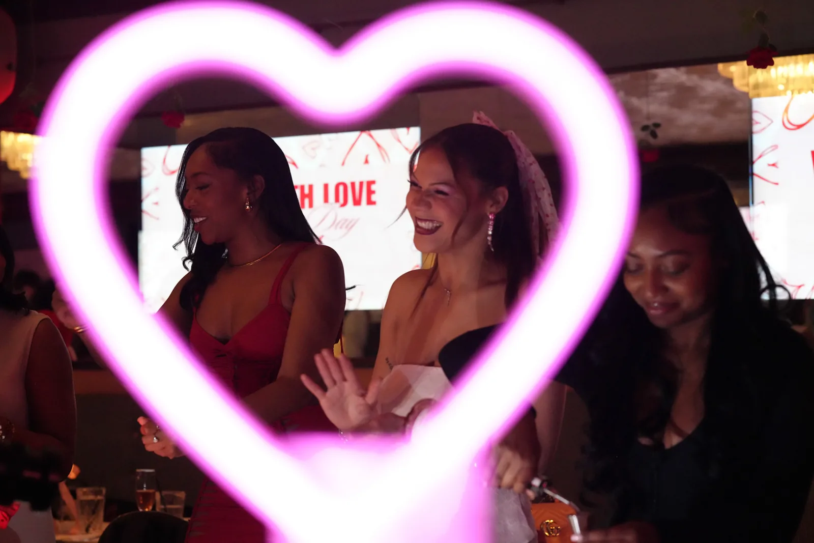 Friends framed by a glowing pink heart-shaped light.