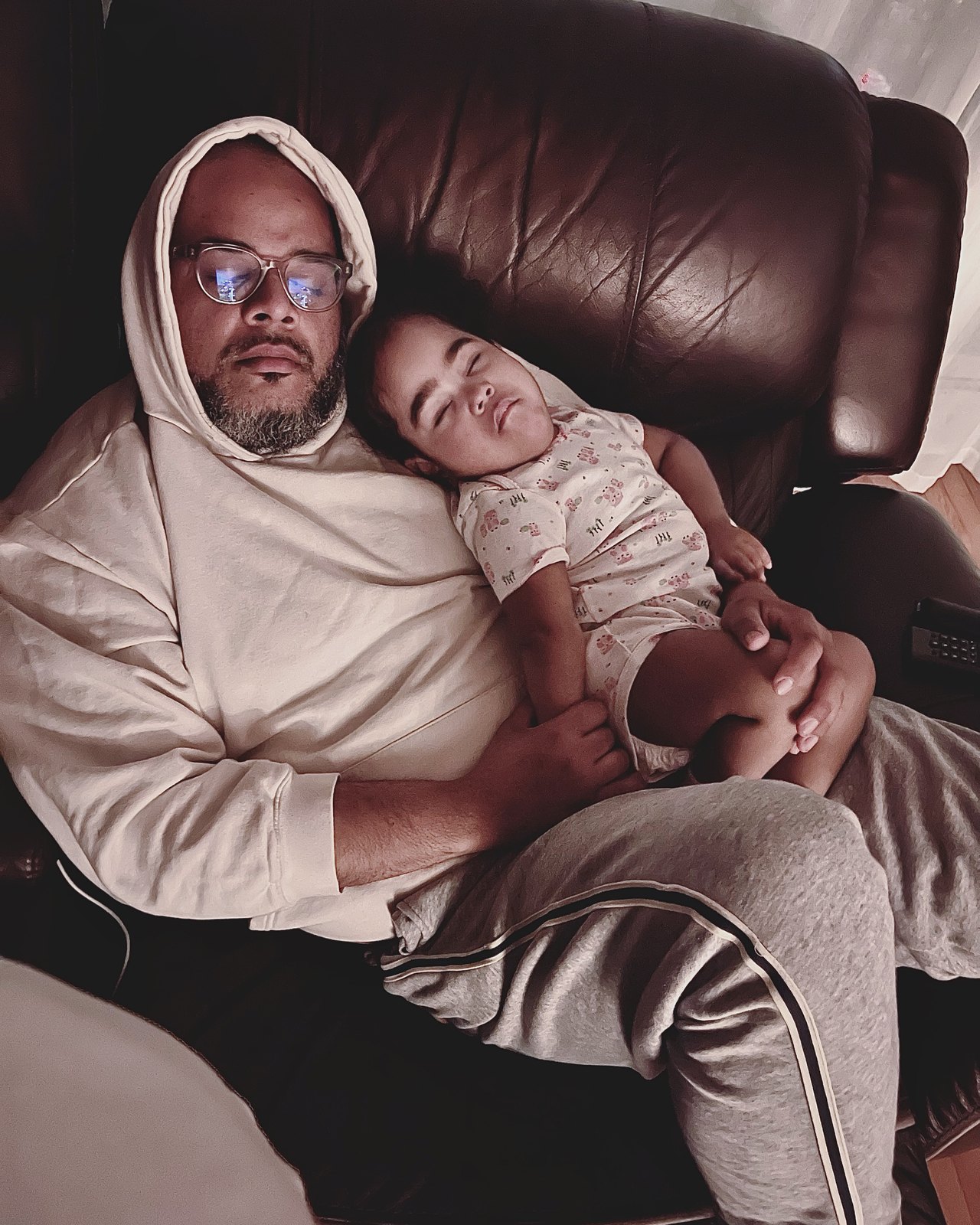 Falú asleep in an armchair with Havana asleep on his chest.